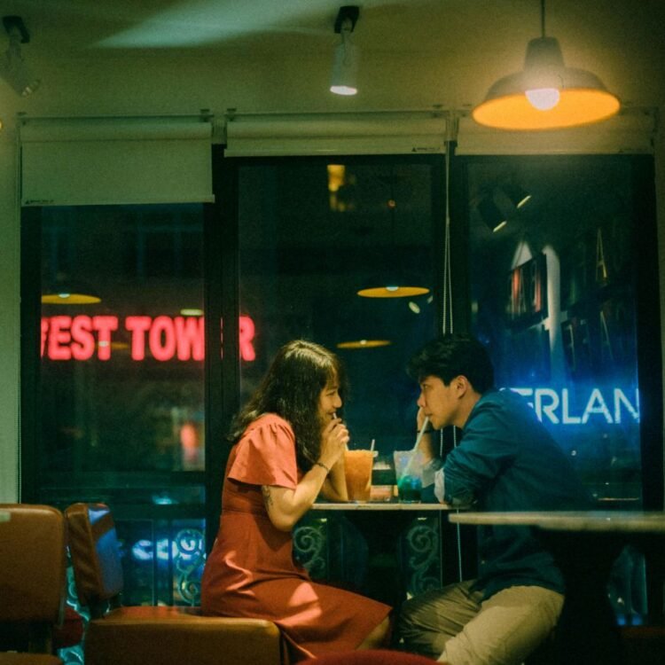 Couple drinking cocktails in cafe at night
