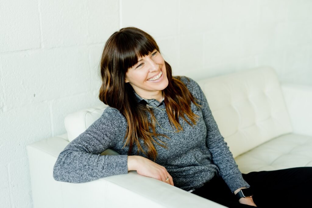 Woman smiles while sitting on the couch