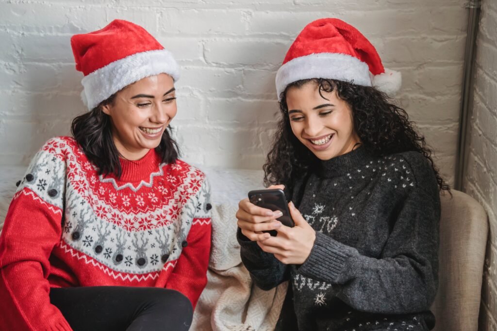 Girlfriends browsing smartphone during Christmas celebration