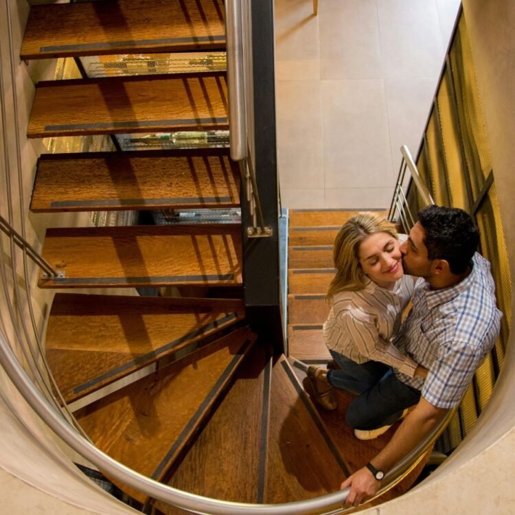 A couple is sitting on a spiral staircase
