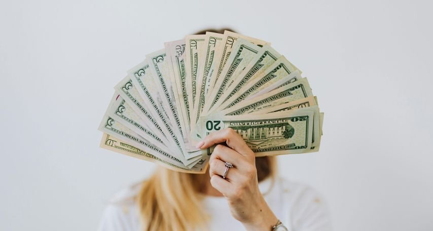 Woman Holding Fan of US Dollar Bills
