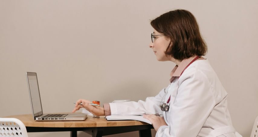Woman in White Scrub Using Laptop