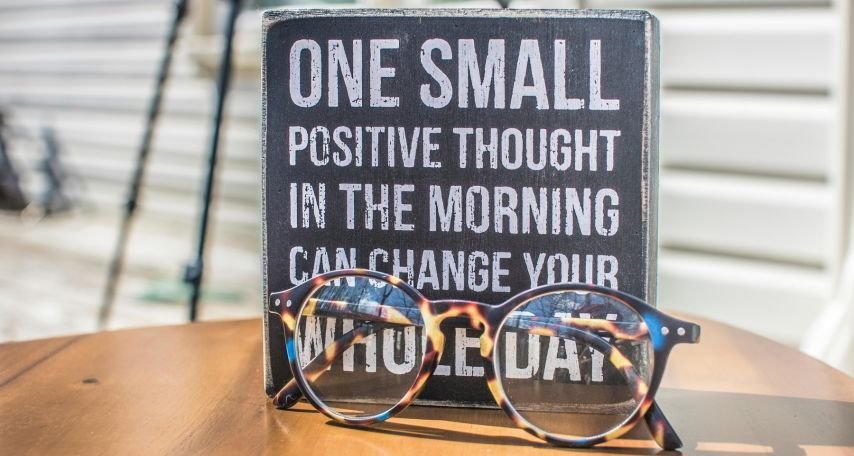 Photo of a Sign and Eyeglasses on Table

