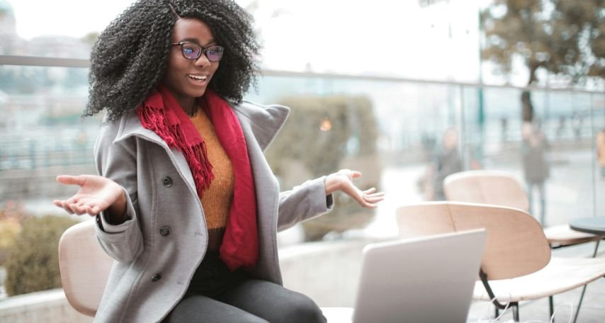Cheerful surprised woman sitting with laptop