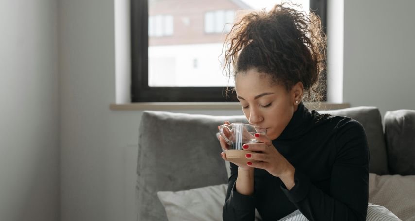 Woman In Black Long Sleeve Shirt Drinking From Clear Drinking Glass
