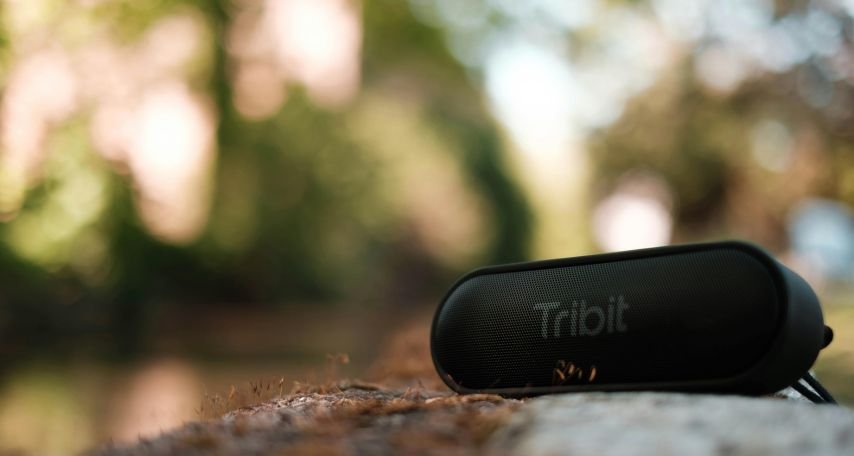 Modern loudspeaker on bench in green park