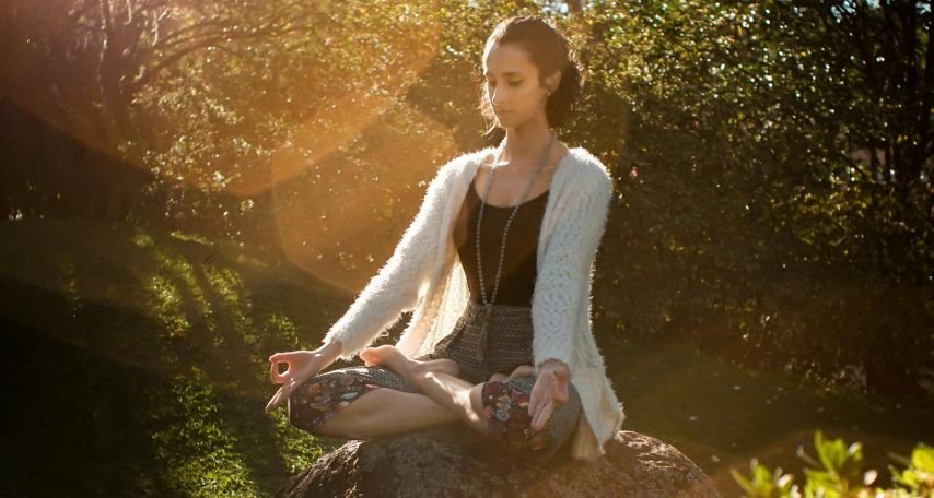 Woman Meditating on Rock