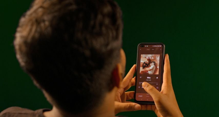 Back View of a Man Playing Music on His Phone