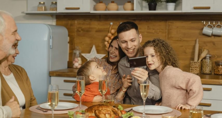 A Happy Family Bonding Time Sitting on a Dining Table
