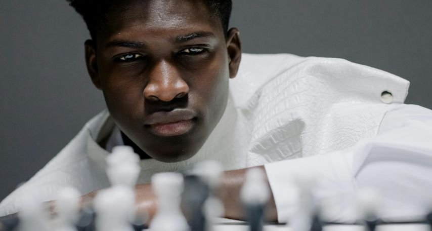 Man in a White Costume and White Chess Pieces
