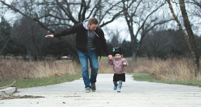 A Father and his Little Girl Running on a Park Pathway