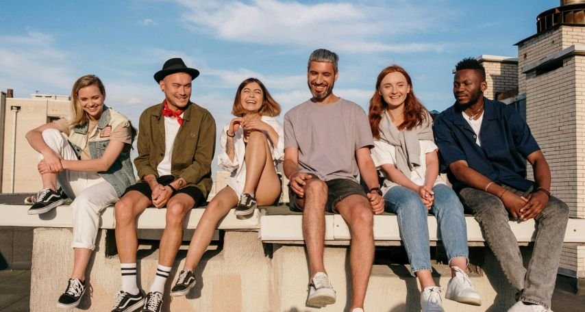 Group of People Sitting on Concrete Bench
