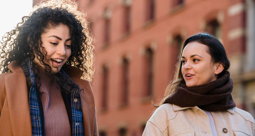 Females strolling on street and chatting
