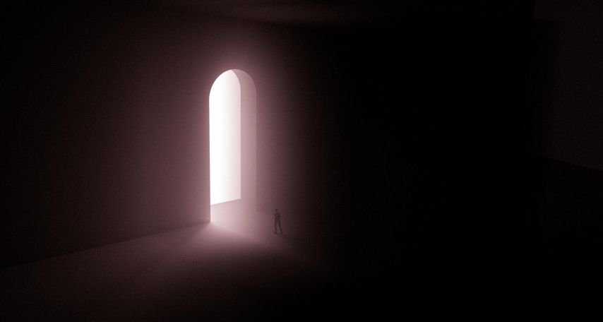 Silhouette of Person Standing Near A Doorway With Bright Light