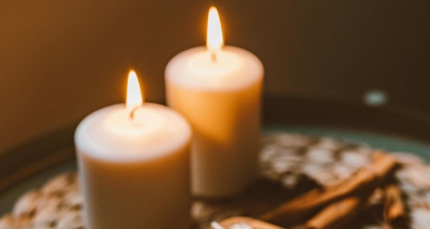 2 Lit Candles on a Table
