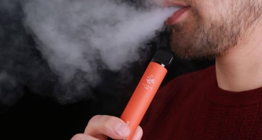 Man in a red top vaping