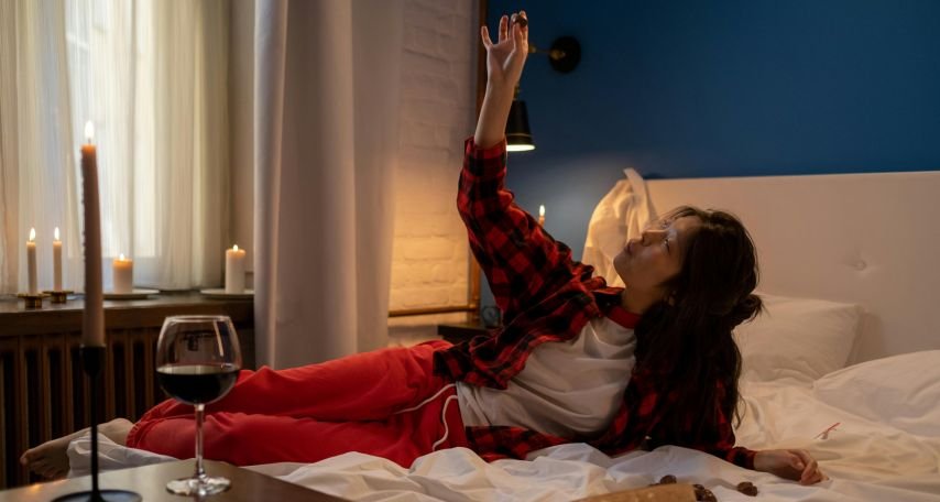 Woman Eating Chocolates in Bed