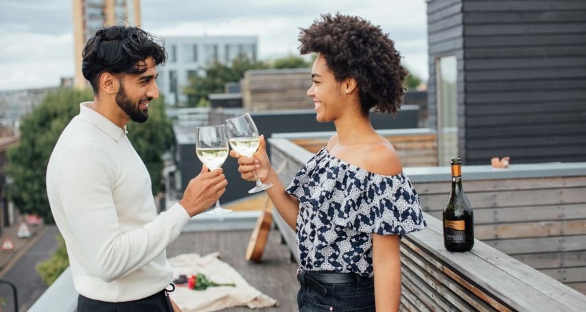 A Couple Toasting their Glasses with White Wine
