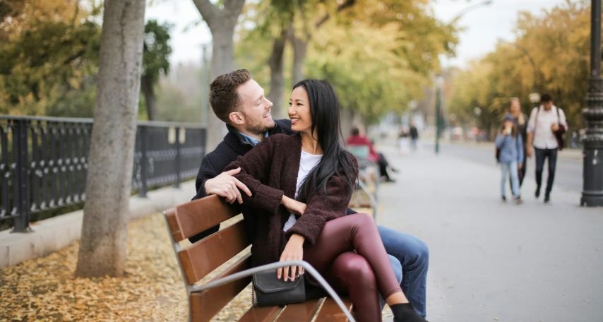 Couple Sitting On Wooden Bench