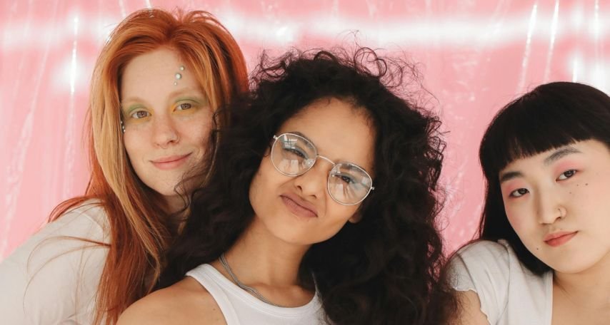 A Group of Young Girls Smiling while Wearing White Tops
