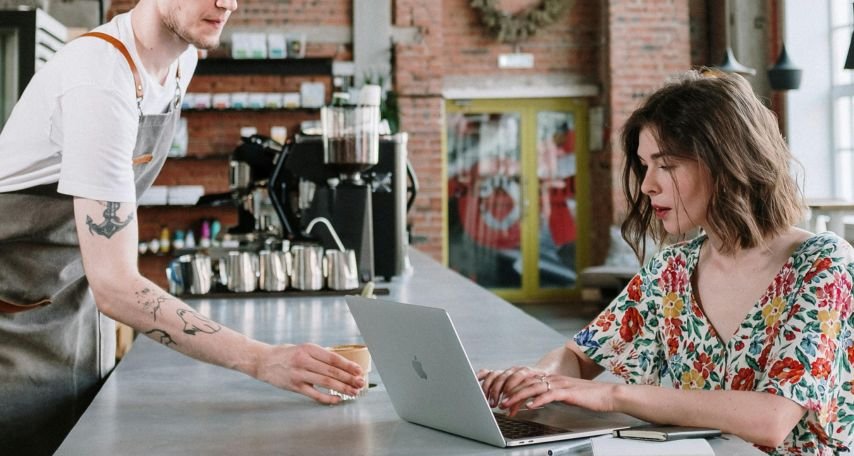 Man in White Crew Neck T-shirt Sitting Beside Woman in Blue and White Floral Sleeveless