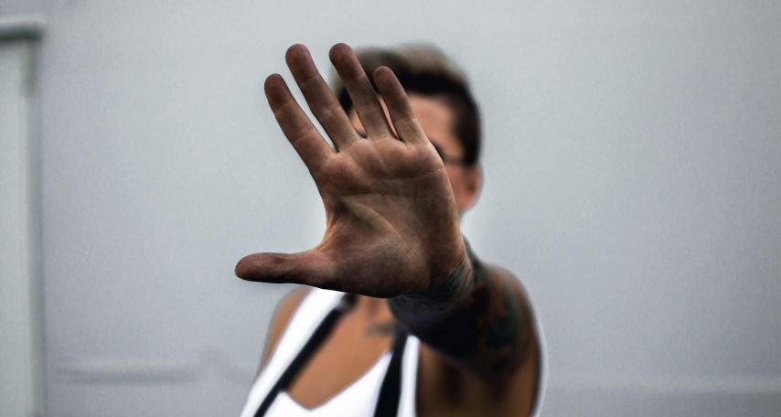 Man in White Top Doing a Stop Sign
