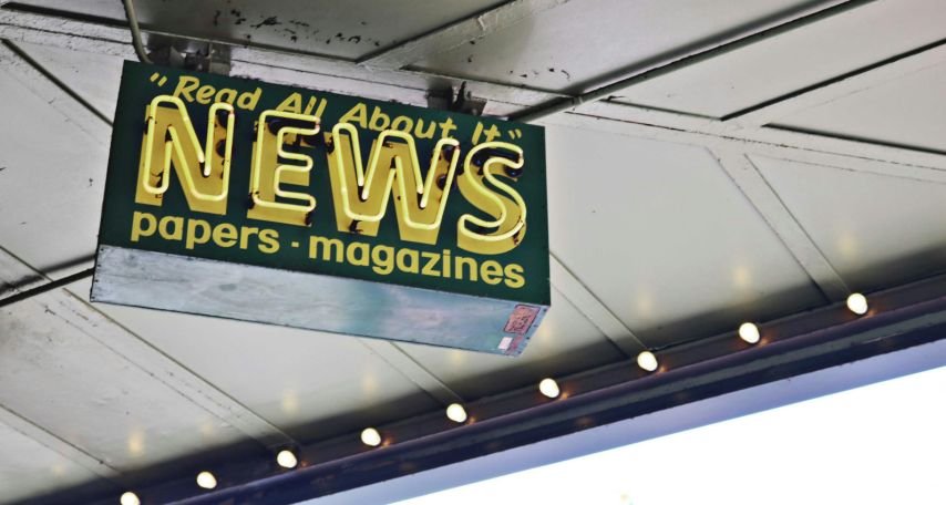 News inscription on neon signboard hanging on street