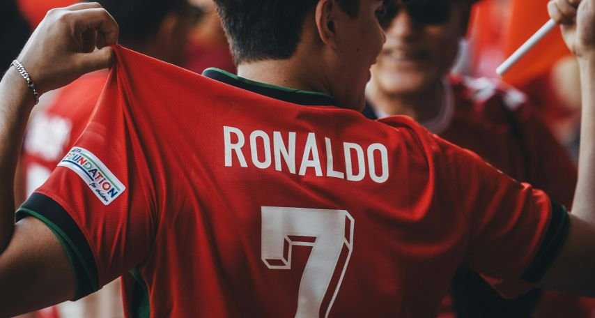 A man holding a soccer jersey with the number 7 on it