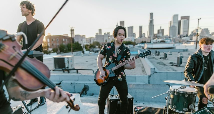Man in Black and White Floral Button Up Shirt Playing Electric Guitar