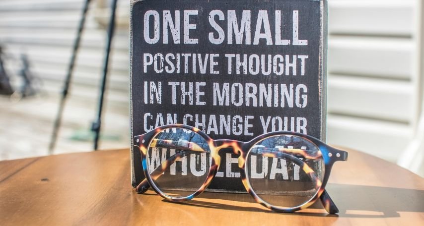 Photo of a Sign and Eyeglasses on Table