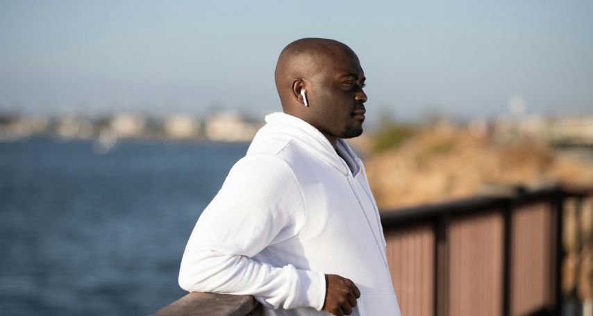 Man in White Hoodie Leaning on a Railing
