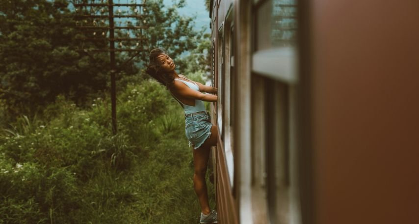 Woman leaning out of train standing in exit door