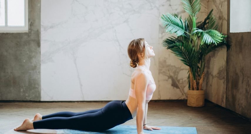 Woman in Pink Sports Bra and Black Leggings Doing Yoga on Yoga Mat
