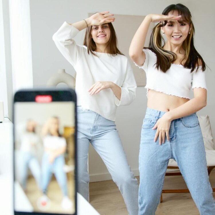 Women in White Top and Denim Jeans Dancing
