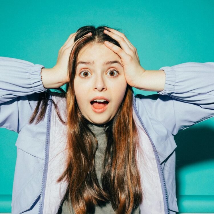 Shocked Girl With her Hands on her Head