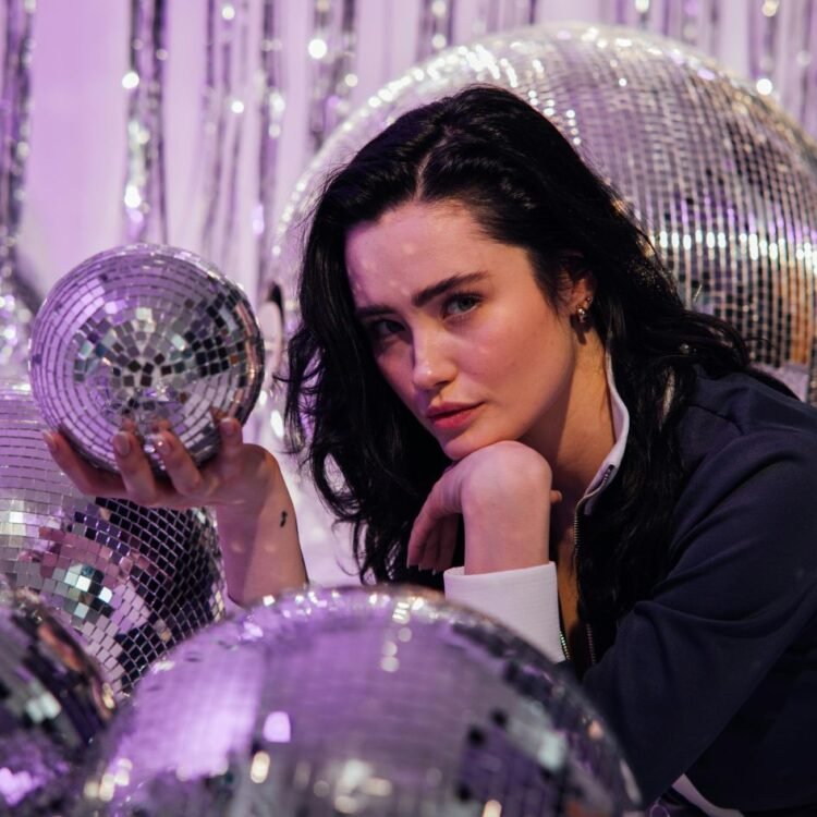 Woman in Tracksuit Posing with a Disco ball
