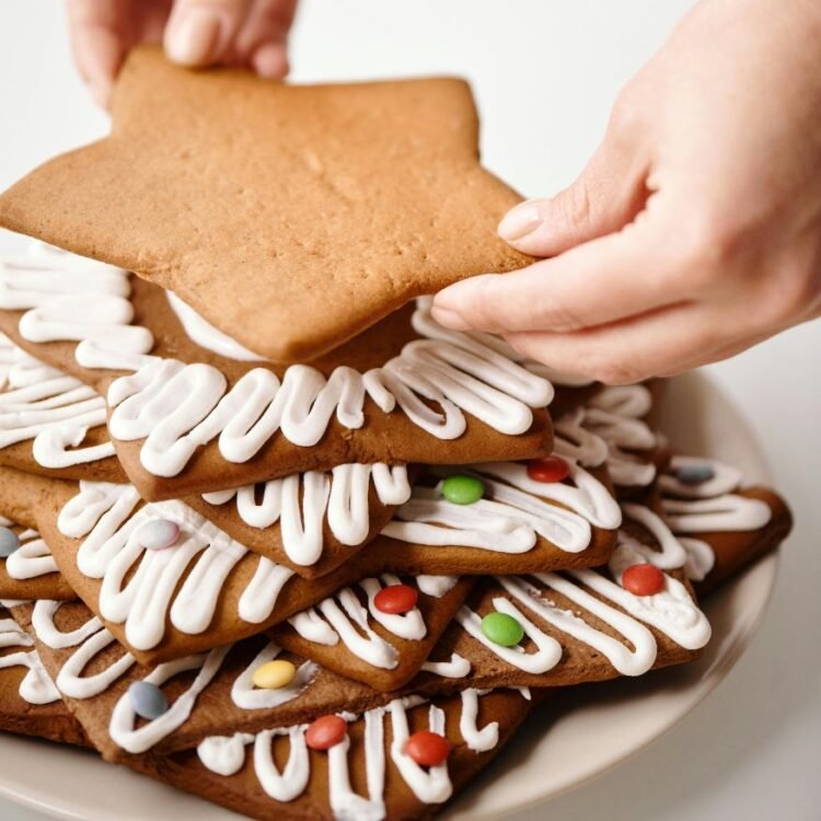 Person Putting Brown Star Shaped Cookie on Top