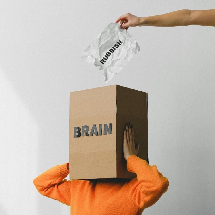 Person putting crumpled paper in box on woman