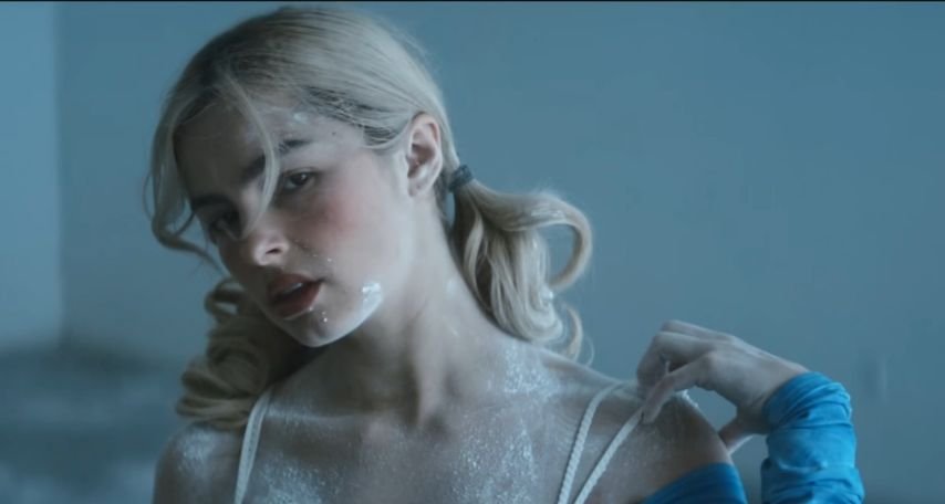 Rae covered in powdered sugar, a nod to her Louisiana roots through beignets, creates one of the video's most striking visuals.