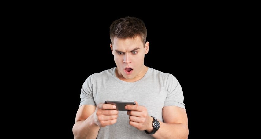 Individual looking shocked at mobile phone message.
