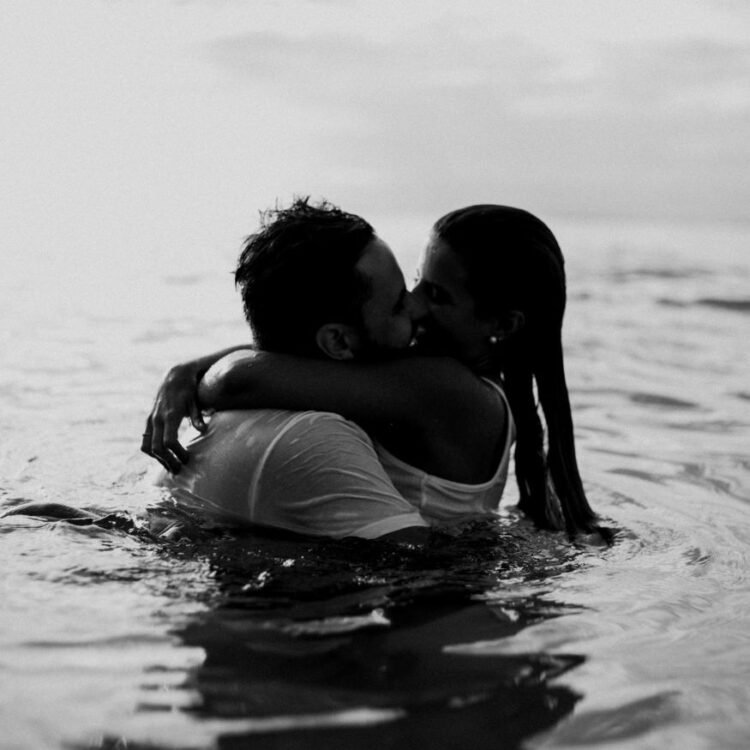 Man and Woman Kissing Together on Body of Water
