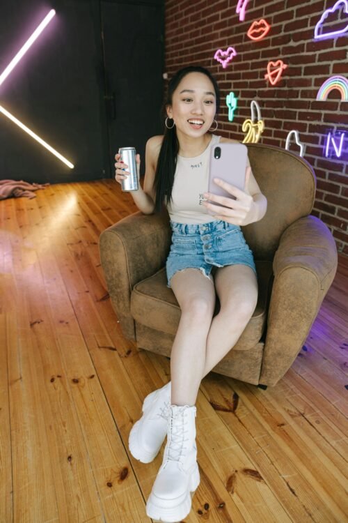 A female creator Sitting while Holding a Mobile Phone